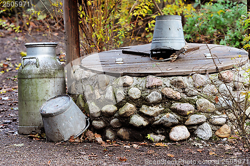 Image of rustic stone well, can and bucket
