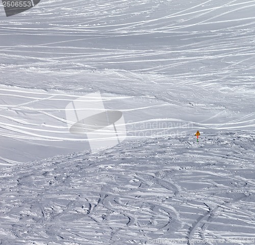 Image of Traces of skis and snowboards in new fallen snow and warning sig