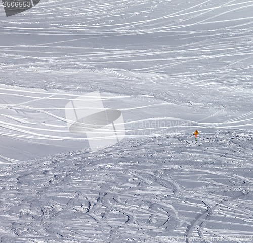 Image of Traces of skis and snowboards in new fallen snow and warning sig