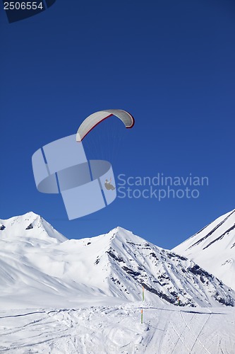 Image of Paraglider in sunny snowy mountains