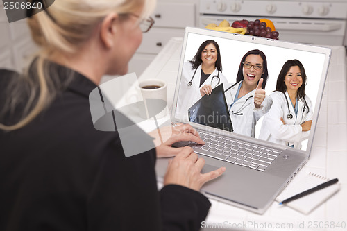 Image of Woman Using Laptop Viewing Three Doctors with Thumbs Up