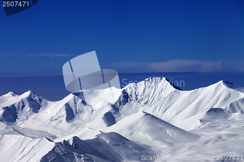 Image of Snowy mountains at sunny day and multicolor blue sky