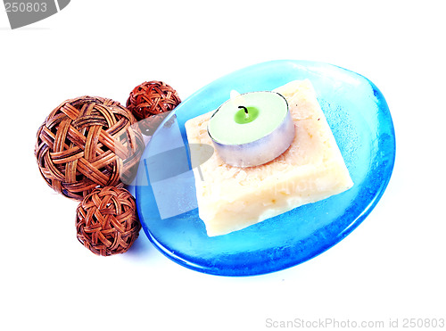 Image of Soap and candle on a blue glass dish