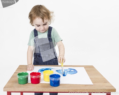 Image of cute girl painting on small desk