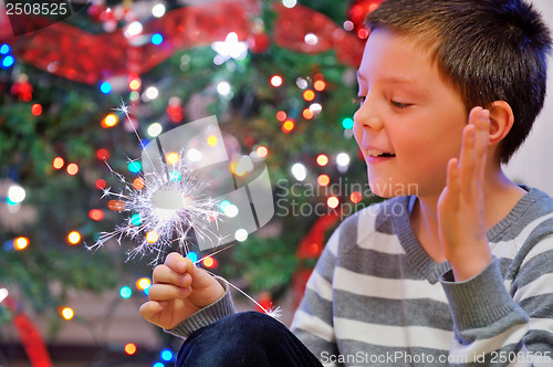 Image of portrait of boy looking at  fire sparks