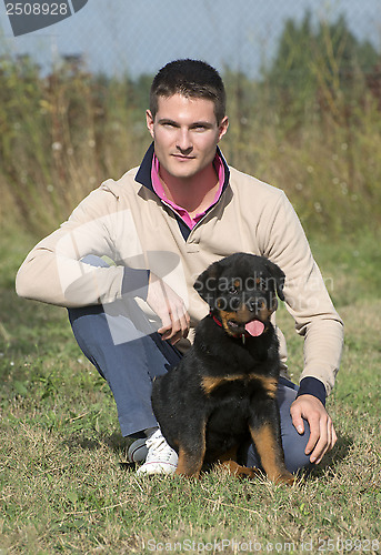 Image of man and puppy rottweiler