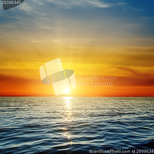 Image of orange sunset over dark blue sea