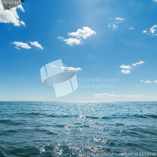 Image of dark blue sea and deep blue sky with clouds