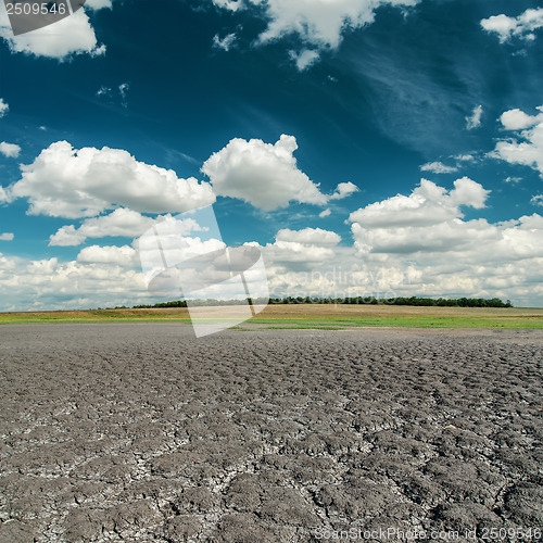 Image of dark sky with clouds over cracked desert