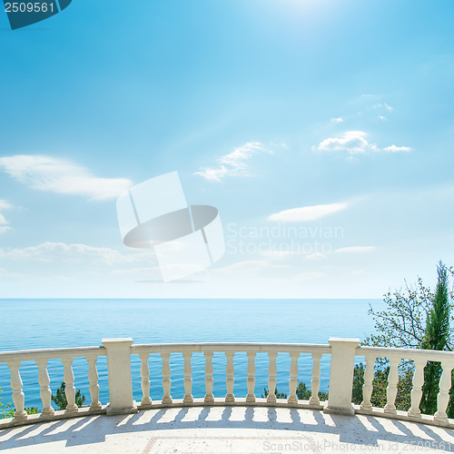 Image of white balcony near sea and light clouds on sky