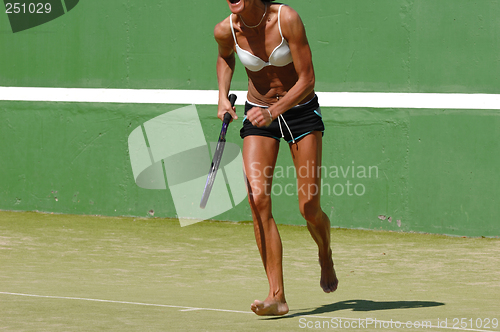 Image of Energetic woman playing tennis.