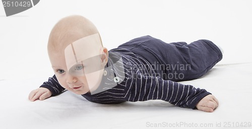 Image of cheerful baby trying to get around