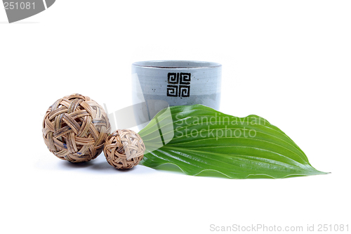 Image of Pottery cup and green leaf