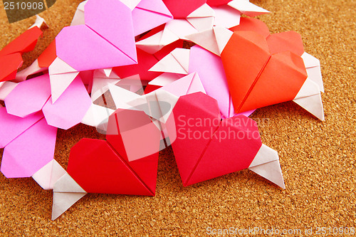 Image of Group of origami colorful heart on corkboard