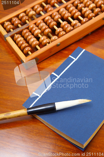 Image of Chinese book , abacus and writing brush