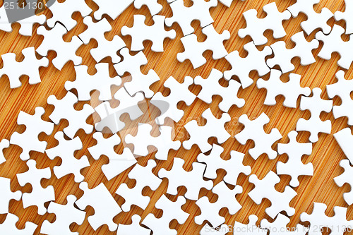 Image of White puzzle on wooden background