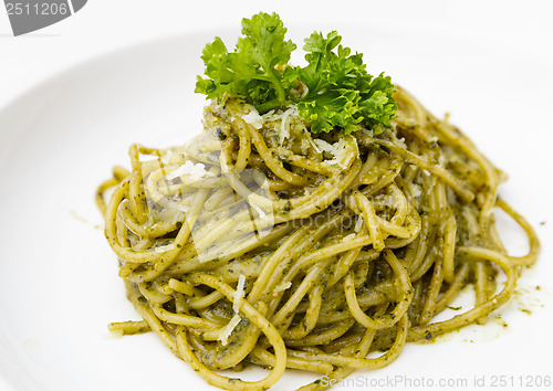 Image of Italian pasta spaghetti with pesto sauce and basil leaf