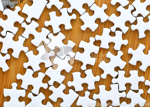 Image of Puzzle pieces with wooden background