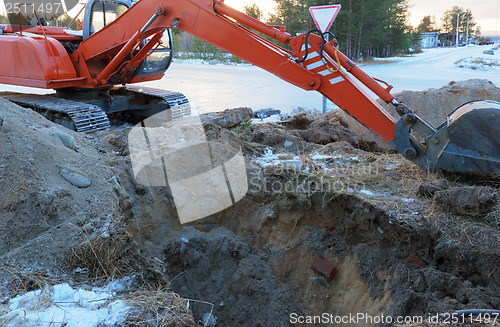 Image of Excavator Tractor Digging a Trench.