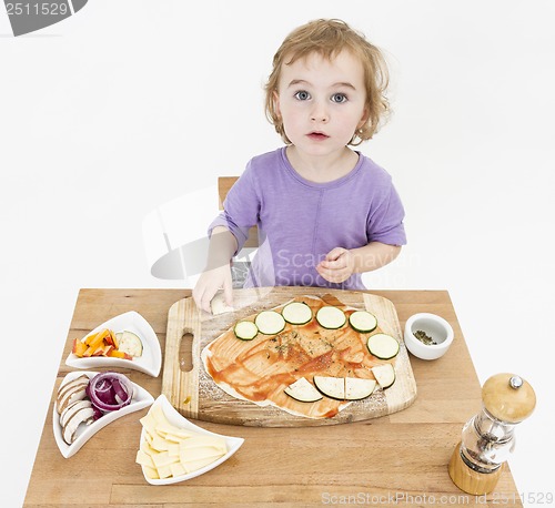 Image of child making pizza