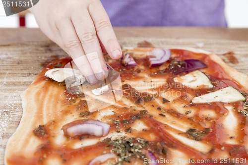 Image of small hands preparing pizza