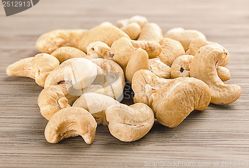 Image of A handful of row cashew nuts on wood background