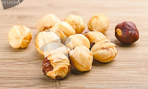 Image of A pile of shell-less hazelnuts, isolated on textural wood backgr