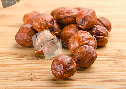 Image of A pile of shell-less hazelnuts, isolated on textural wood backgr