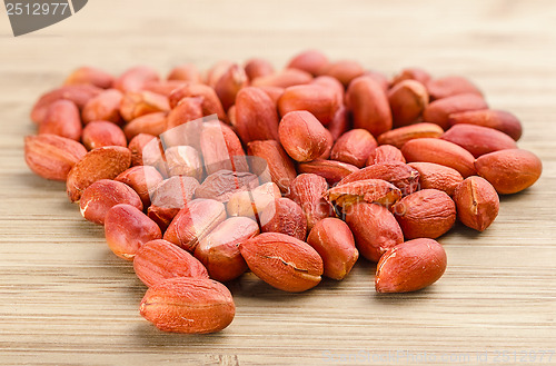 Image of heap of roasted peanuts on the wooden background