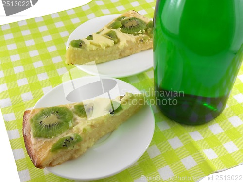 Image of kiwi tasty cake close up at plate and champagne bottle