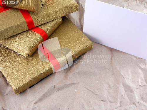 Image of golden gift box with red bow on vintage old paper