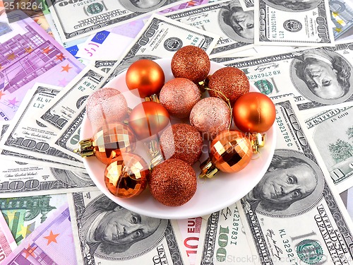 Image of Christmas balls set on white plate, dollar background