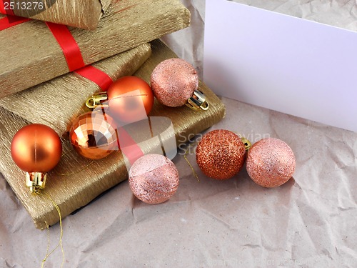 Image of Golden gift box set with red ribbon, christmas balls and empty card