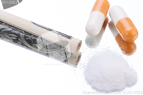 Image of illegal pharmaceutical pills and drugs money on mirror