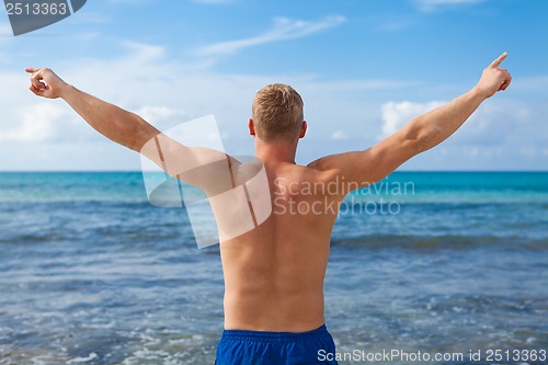 Image of attractive young athletic man on the beach