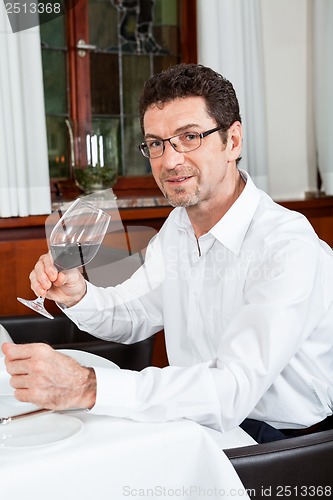 Image of couple drinking red wine in restaurant