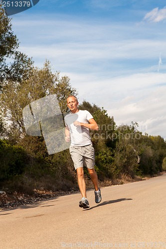 Image of athletic man runner jogging in nature outdoor