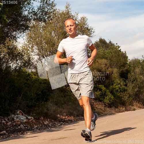 Image of athletic man runner jogging in nature outdoor