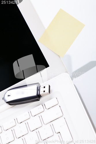 Image of notebook laptop with post it memo and usb stick 