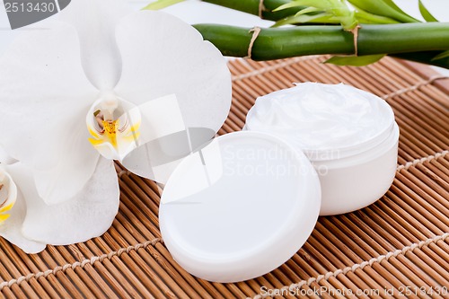 Image of cosmetic face cream on wooden background 