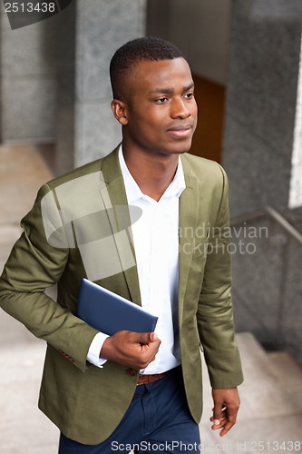 Image of smiling successful businessman with tablet pc outdoor