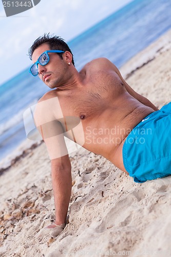 Image of attractive young athletic man on the beach
