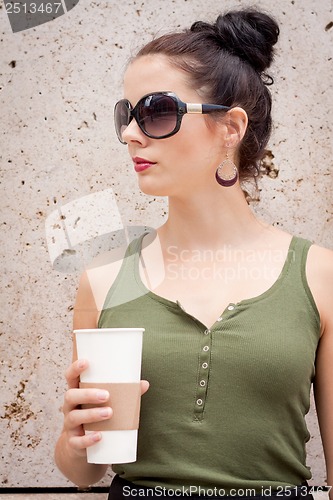 Image of attractive young woman with smartphone and sunglasses outdoor