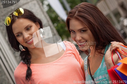 Image of two attractive young girls women on shopping tour