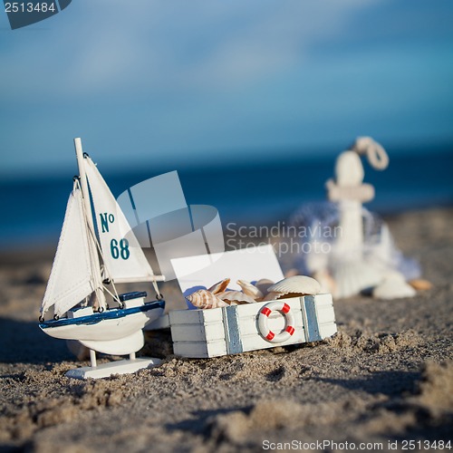 Image of sailing boat and seashell in sand decoration closeup