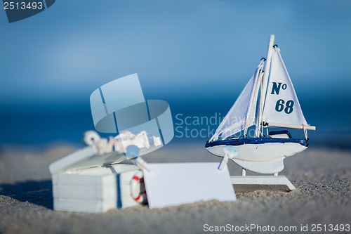 Image of sailing boat and seashell in sand decoration closeup