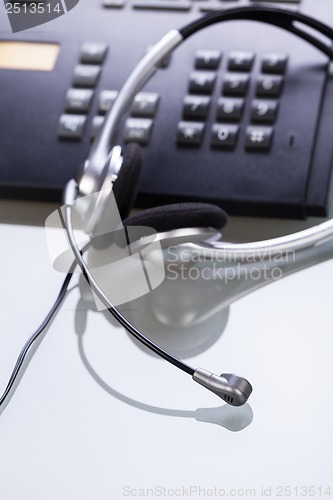 Image of office desk with telephone and headset objects 