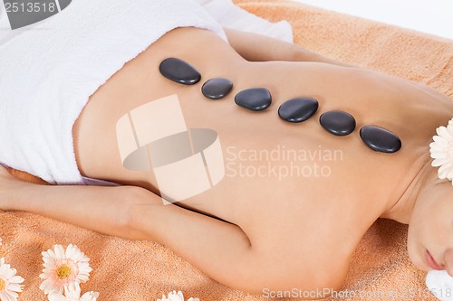 Image of attractive healthy caucasian woman hot stone massage wellness 