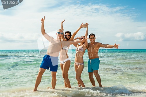 Image of young happy friends havin fun on the beach