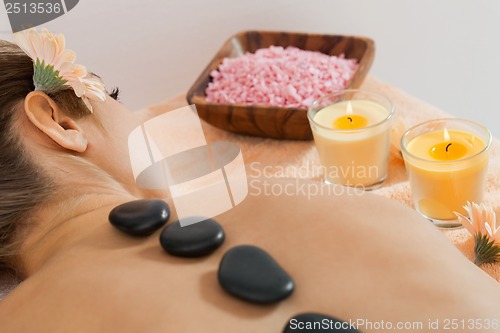 Image of attractive healthy caucasian woman hot stone massage wellness 